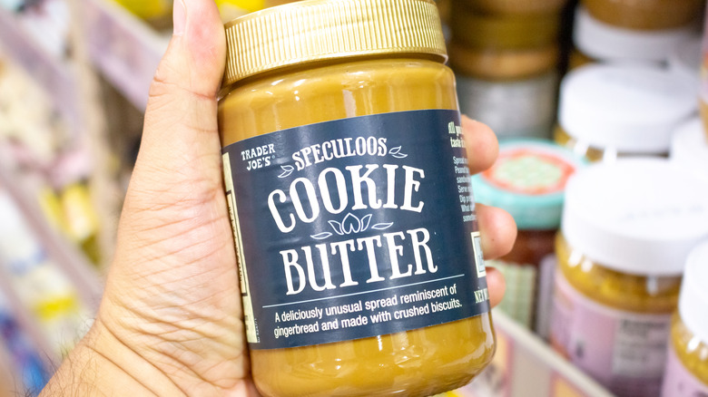someone holding a jar of Trader Joe's cookie butter