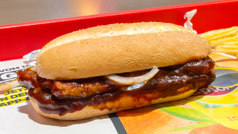 A McRib sandwich on a red McDonald's tray