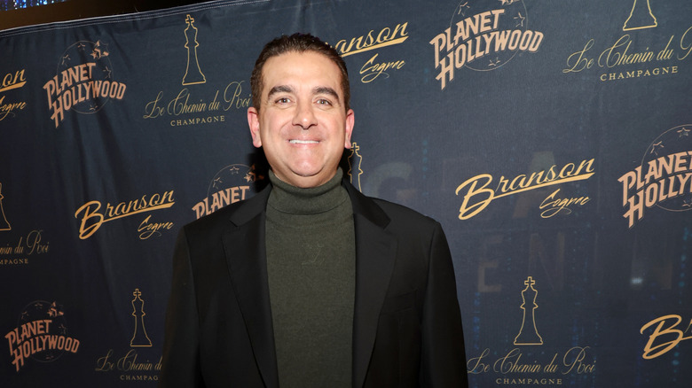 Buddy Valastro smiling in front of a black backdrop