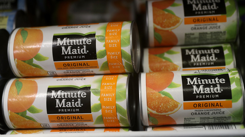 Cans of frozen Minute Maid concentrate on store shelf.