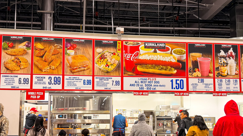 Menu boards at a crowded Costco food court