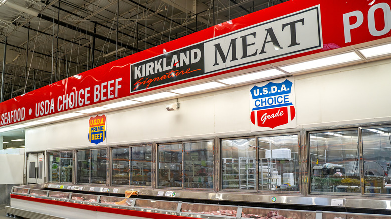 A Kirkland Meat Department with signs for seafood, USDA Choice and Prime beef, and poultry