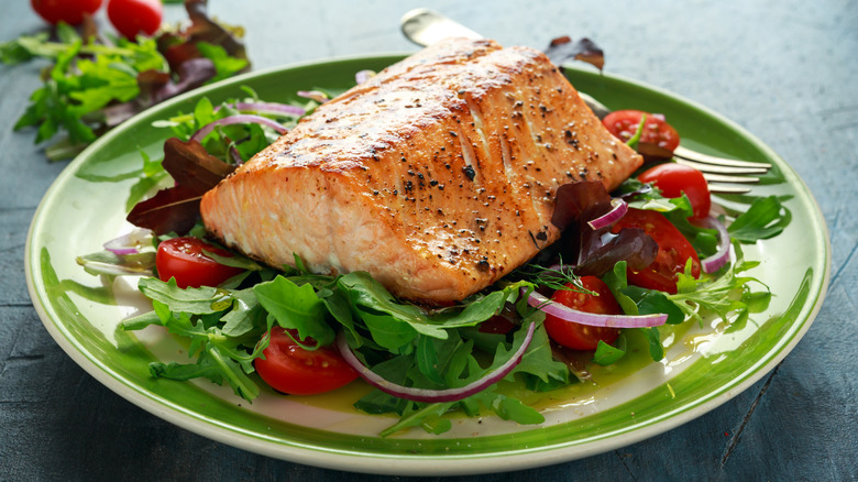Baked salmon steak on a salad