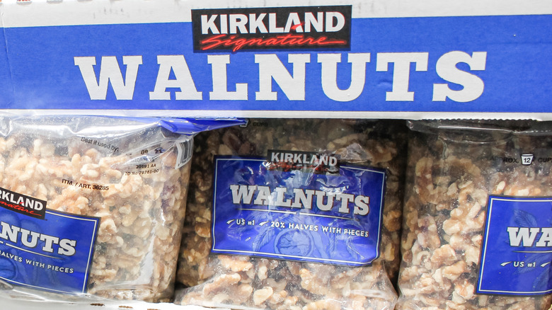 A closeup of Kirkland bagged walnuts with a blue label in a clear bag on the shelf