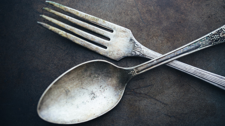 Silver flatware on a black surface