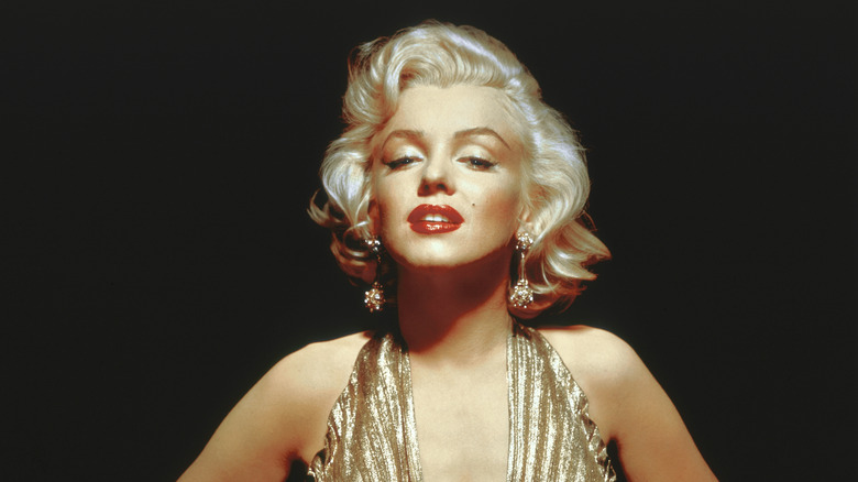Close up of Marilyn Monroe in a gold dress with a black background