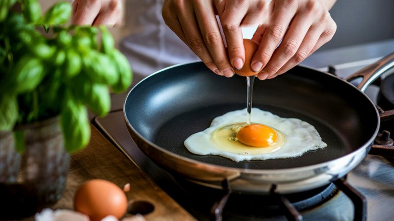 Cracking eggs into a frying pan