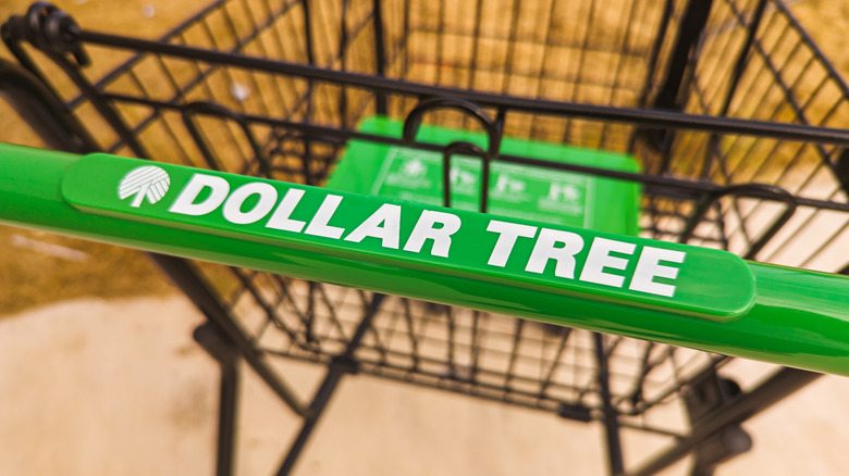 The green handle of a Dollar Tree cart that says Dollar Tree on it in white font