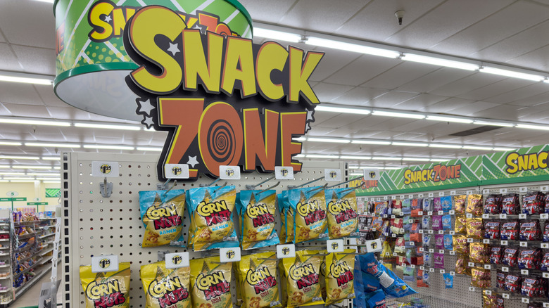 A sign inside a Dollar Tree that says "Snack Zone" in vibrant yellow and orange