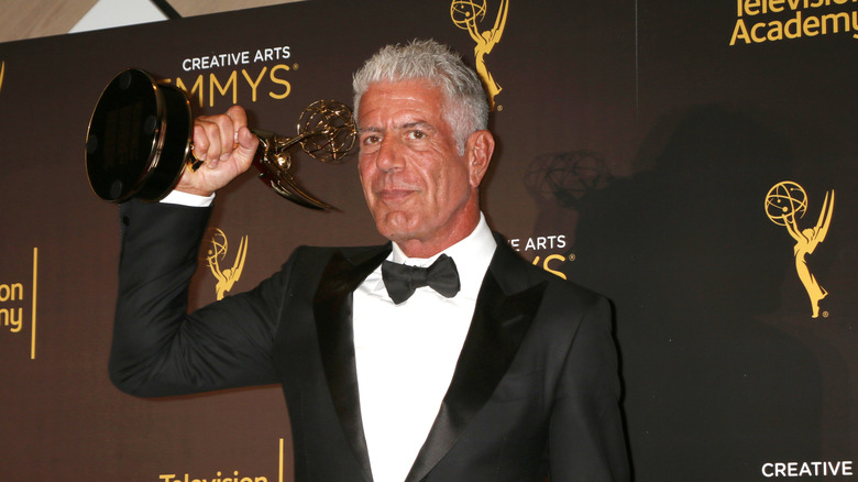 Anthony Bourdain holding a Creative Arts Emmy