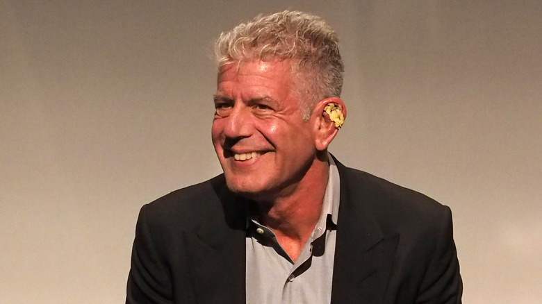 Anthony Bourdain in a suit, smiling