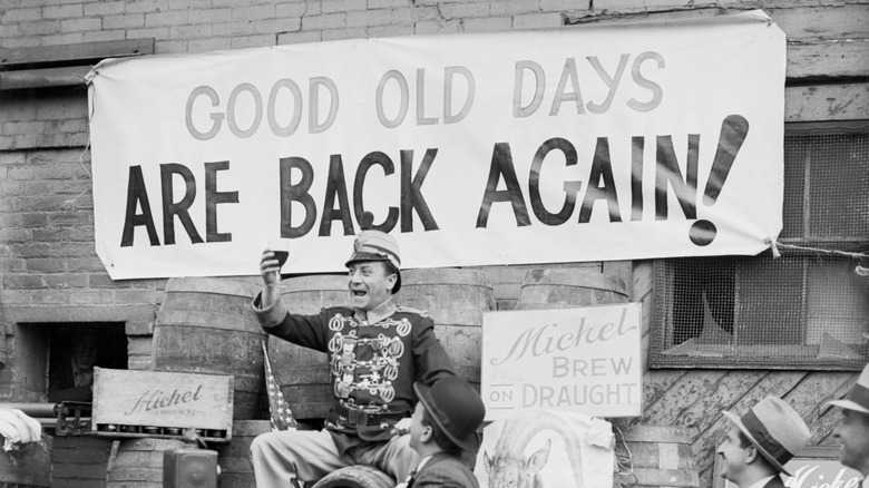 A man in military costume toasting prohibition's end. A banner behind him says "Good Old Days Are Back Again!"
