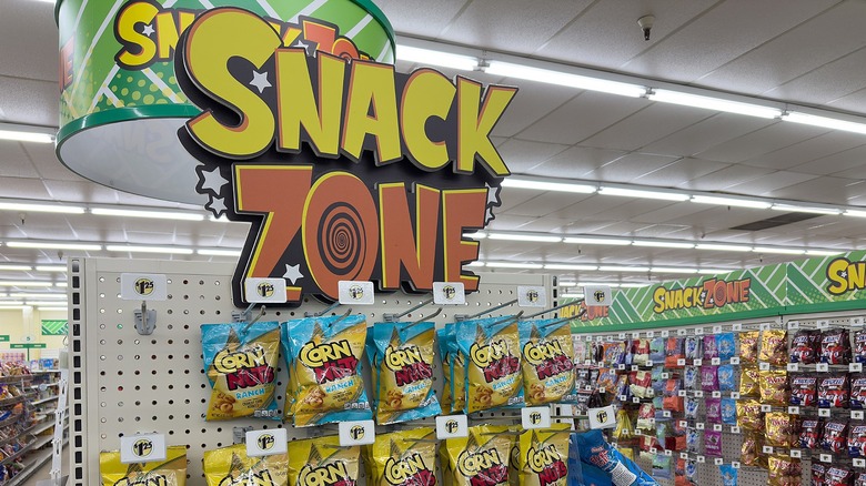 A Snack Zone sign in a supermarket aisle with lots of snack packets in the shots